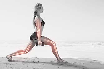 Frau am Strand im Sportoutfit macht Ausfallschritt. Mit Hanteln in der Hand. Knochenstruktur wird nachgezeichnet und hervorgehoben.